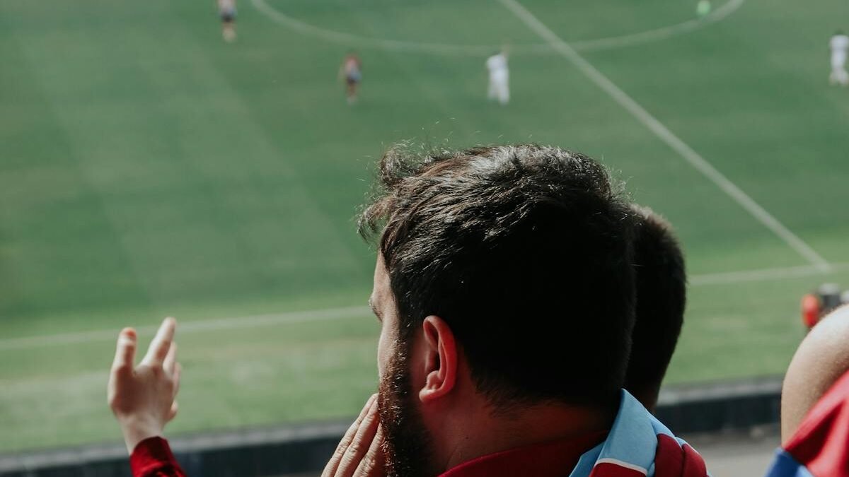 Bārdains vīrietis skatās futbola spēli
