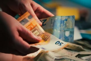 Eiro banknošu skaitīšana blāvā apgaismojumā
