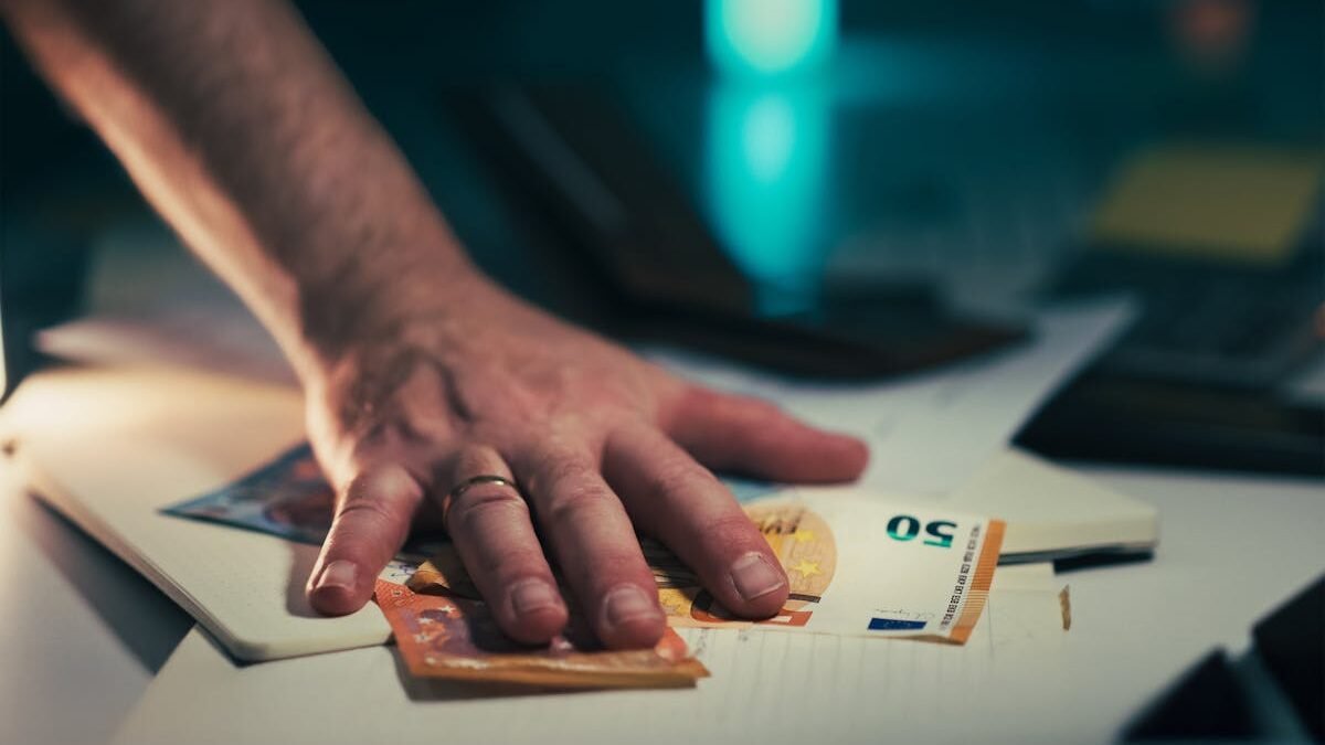Roka satver eiro banknotes uz galda