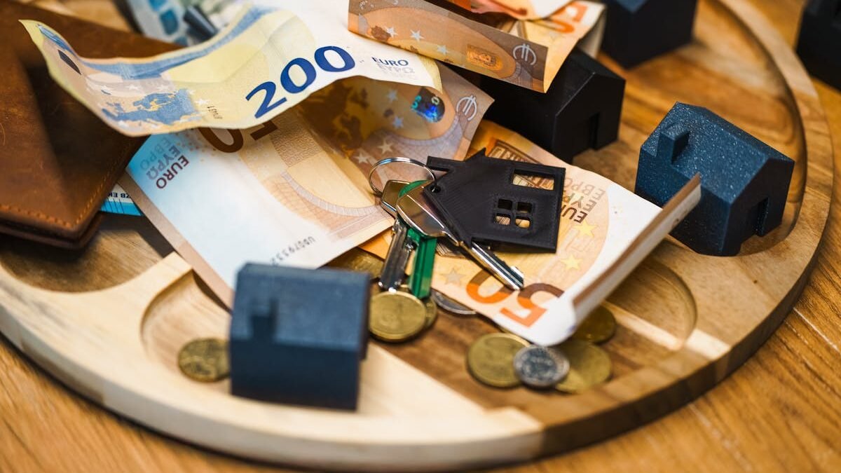 Eiro banknotes un atslēgas ar māju miniatūrām