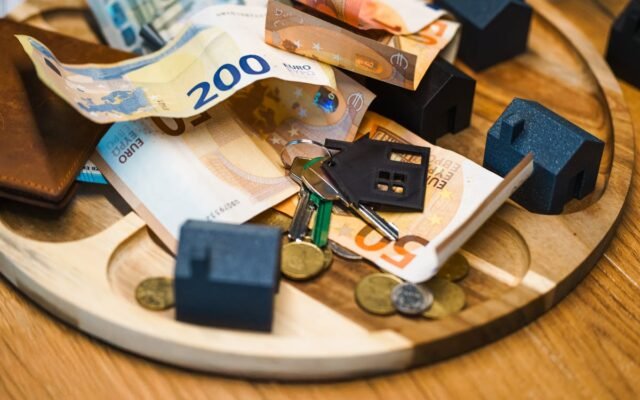 Eiro banknotes un atslēgas ar māju miniatūrām