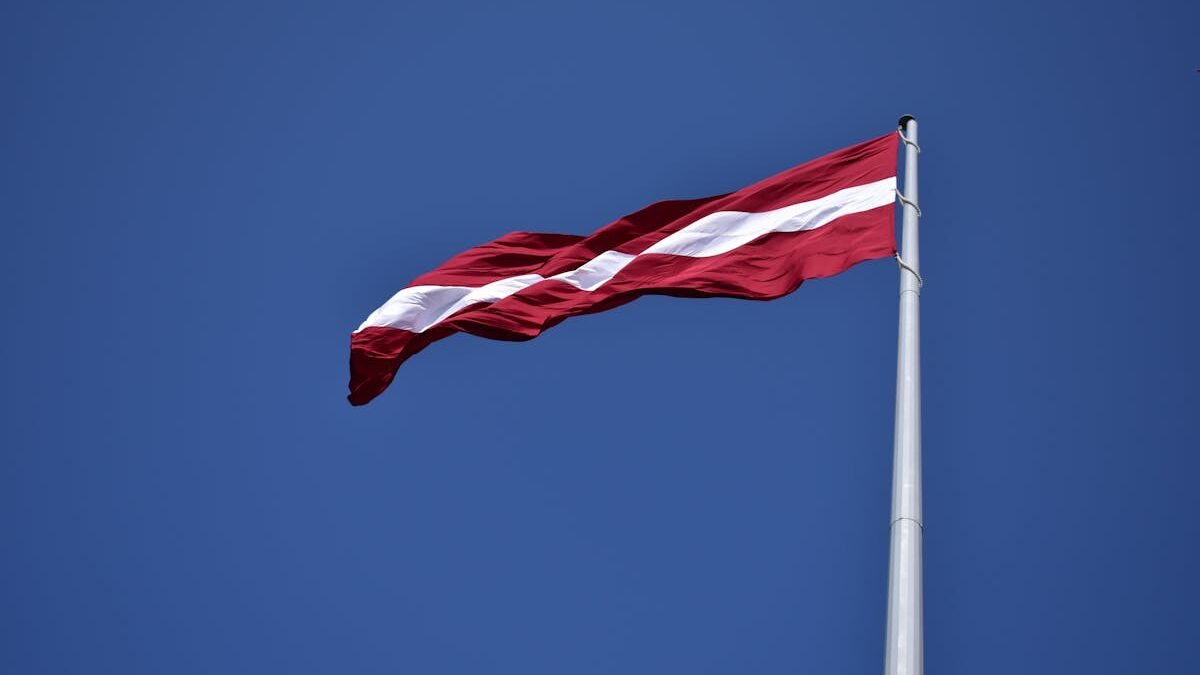 Red and White State Flag Waving Under Blue Sky at Daytime