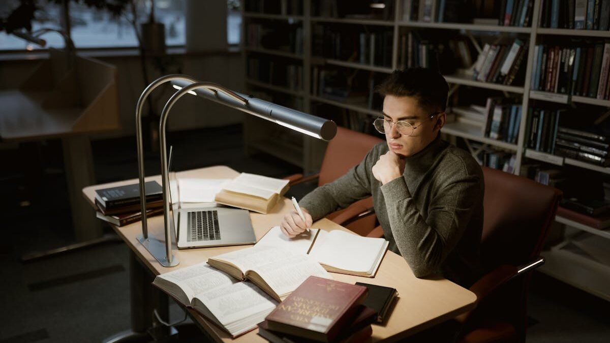 Vīrietis lasa bibliotēkā
